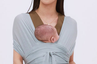 Newborn snug on a mother's chest in a mint grey Konny Baby Carrier FLEX AirMesh™, light studio background